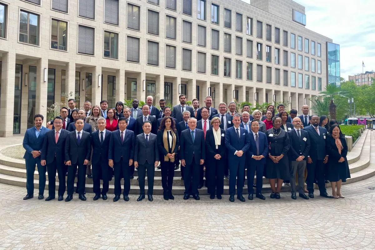 Group photo of delegates on the steps of a building